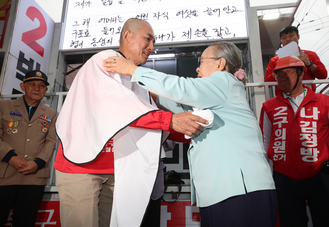 박민식 국민의힘 부산 북갑 후보가 21일 부산 구포시장 쌈지공원에서 열린 출정식에서 삭발한 뒤 어머니와 포옹하고 있다. [연합뉴스]