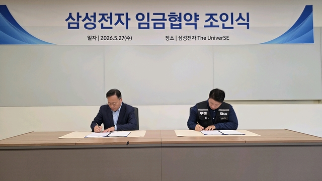 여명구(왼쪽) 삼성전자 부사장, 최승호 초기업노조 삼성전자지부 위원장이 27일 경기 용인 기흥사업장 더 유니버스(The UniverSE)에서 2026년 임금협약 조인식에서 서명을 하고 있다. 삼성전자 제공
