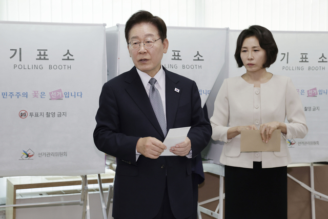 이재명 대통령이 제9회 전국동시지방선거 사전투표 첫날인 29일 서울 종로구 삼청동 주민센터에서 사전 투표 중 기표 도장 관련 문의를 하고 있다. 연합뉴스