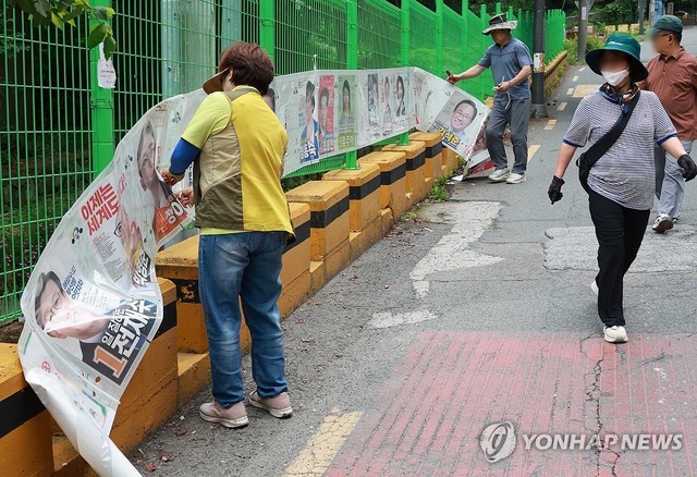 4일 부산 연제구 일원에서 관계자들이 선거 벽보를 철거하고 있다. 선거는 막을 내렸지만 정치권의 진짜 과제는 지금부터다. 연합뉴스
