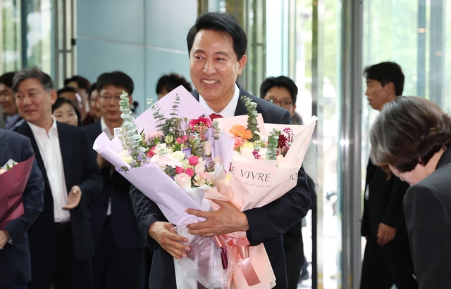 오세훈 서울시장이 4일 서울시청 로비에서 꽃다발을 받은 뒤 기뻐하고 있다.  [연합뉴스]