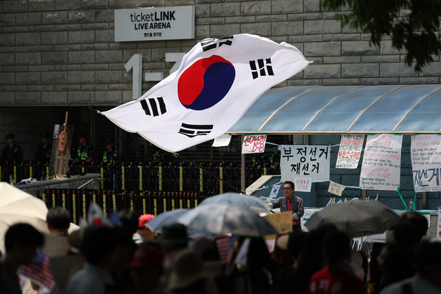 6·3 지방선거 투표용지 부족 사태를 규탄하며 재선거를 요구하는 ‘잠실 개표소 봉쇄 시위’가 계속되고 있는 9일 서울 송파구 올림픽공원 핸드볼경기장에서 시민들이 구호를 외치고 있다. [연합뉴스]