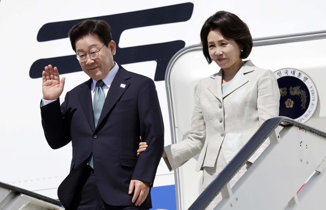 벨기에를 방문한 이재명 대통령과 김혜경 여사가 9일(현지시간) 브뤼셀 멜스부르크 공군 기지에 도착한 공군 1호기에서 환영객에게 인사하고 있다. [연합뉴스]
