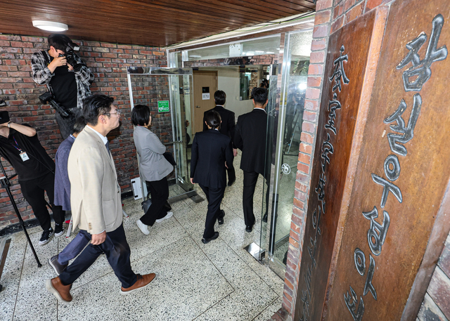 서울동부지방법원 관계자들이 10일 6·3 지방선거 당시 서울 송파구 잠실7동 제2투표소였던 아파트 노인정에 도착해 증거물 확보 등 현장검증을 위해 건물 내부로 들어가고 있다. [공동취재·연합뉴스]