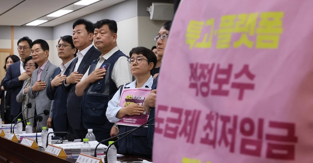 11일 정부세종청사 최저임금위원회에서 열린 제5차 전원회의에서 근로자위원과 사용자위원들이 국기에 경례하고 있다. 왼쪽 다섯번째부터 여덟번째까지 최임위 사용자위원인 양옥석 중소기업중앙회 인력정책본부장과 류기정 한국경영자총협회(경총) 전무, 근로자위원인 류기섭 한국노총 사무총장과 민주노총 이미선 부위원장. [연합뉴스]