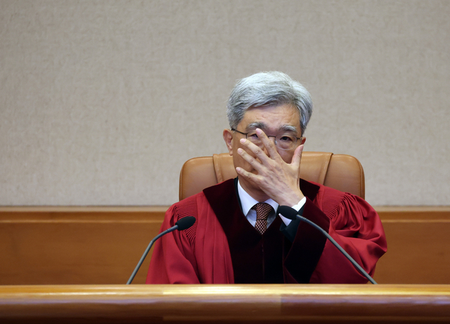 김상환 헌법재판소장이 지난 5월 21일 서울 종로구 헌법재판소 심판정에서 열린 아동ㆍ청소년의 성보호에 관한 법률 제18조 위헌제청 선고에서 안경을 고쳐쓰고 있다. [연합뉴스]