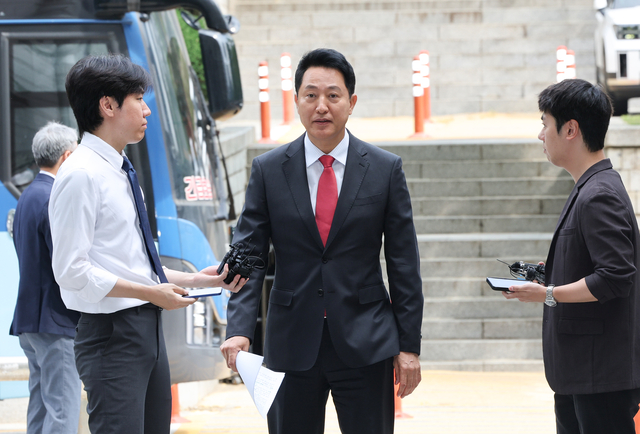오세훈(가운데) 서울시장이 17일 서울 서초구 서울중앙지방법원에서 열린 ‘명태균 여론조사 의혹’ 사건 1심 결심공판에 출석하며 취재진의 질문을 듣고 있다. [연합뉴스]