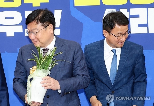 정점식 국민의힘 신임 원내대표(왼쪽)가 지난 11일 국회에서 취임 인사차 한병도 더불어민주당 원내대표를 방문, 축하 난을 선물 받고 있다. 연합뉴스