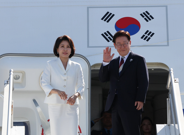G7 정상회의와 유럽 순방을 마친 이재명 대통령과 김혜경 여사가 17일(현지시간) 스위스 제네바 공항 공군 1호기에서 환송객에게 인사하고 있다. [연합뉴스]