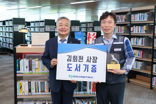 김회천(왼쪽) 한수원 사장이 30일 사내 도서관인 청심재에 개인 소장 도서 300여권을 기증한 뒤 기념촬영을 하고 있다. [한수원 제공]