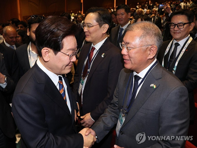 이재명 대통령이 지난 4월 20일(현지시간) 인도 뉴델리 바라트 만다팜 컨벤션센터에서 열린 한-인도 비즈니스포럼을 마친 후 퇴장하며 정의선 현대차그룹 회장과 악수하고 있다. [연합뉴스]