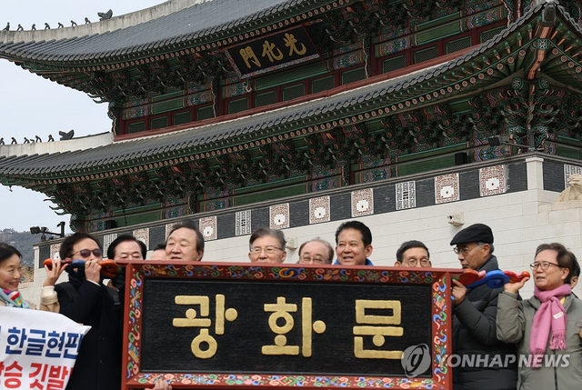 지난 3월 1일 광화문 앞에서 광화문 훈민정음체 한글현판 국민모임 주최로 열린 ‘3.1절 맞이 광화문 훈민정음체 한글현판 설치 범국민 출범식’에서 예시현판 모형이 공개되고 있다. [연합뉴스]