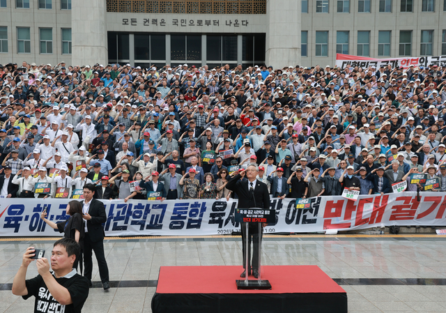 국회 본청 앞 계단에서 육·해·공군사관학교 총동창회, 육사 사관생도 학부모 모임 등 참석자들이 8일 연 육·해·공군사관학교 통폐합 및 육군사관학교 지방 이전 반대 총궐기 대회에서 국기에 경례하고 있다. 연합뉴스