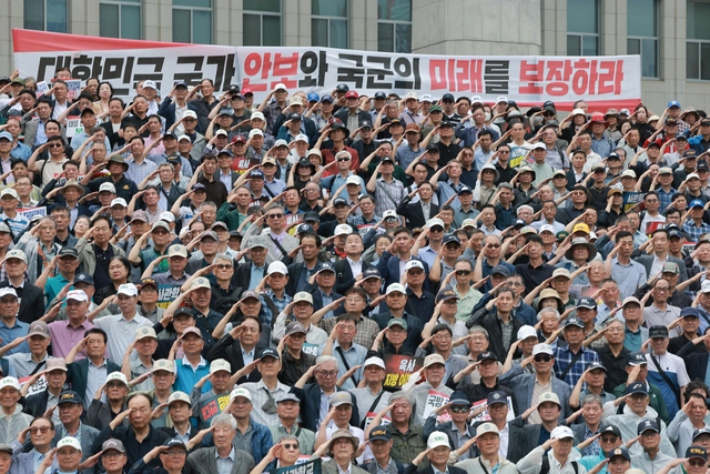 8일 국회 본청 앞 계단에서 육군 장성 출신 한기호·임종득 국민의힘 의원이 육·해·공군사관학교 총동창회, 육사 사관생도 학부모 모임과 함께 연 육·해·공군사관학교 통폐합 및 육군사관학교 지방 이전 반대 총궐기 대회에서 참석자들이 국기에 경례하고 있다. [연합뉴스]