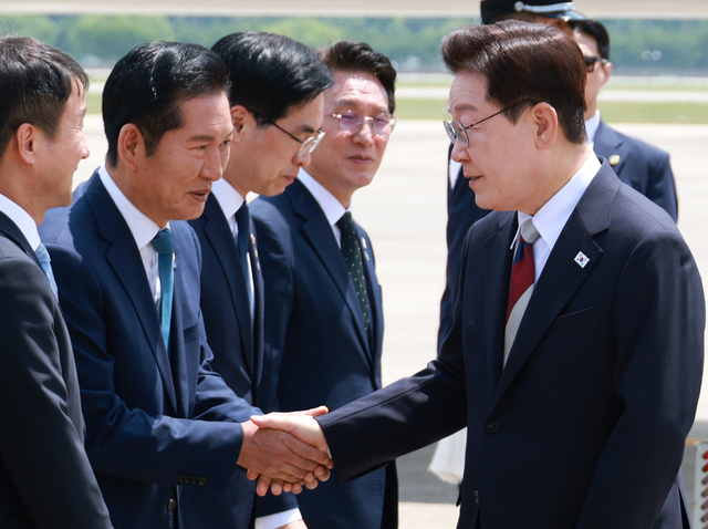 이재명 대통령이 G7 정상회의와 유럽 순방을 마치고 귀국한 지난 6월 18일 성남 서울공항에서 환영나온 정청래(왼쪽 두번째) 당시 더불어민주당 당대표와 인사하고 있다. 왼쪽 네번째는 김민석 당시 국무총리. [연합뉴스]