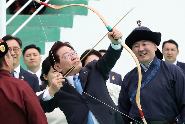 몽골을 국빈방문 중인 이재명 대통령이 11일(현지시간) 울란바타르 나담축제장에서 전통 활을 쏘고 있다. 오른쪽은 오흐나 후렐수흐 몽골 대통령.  연합뉴스