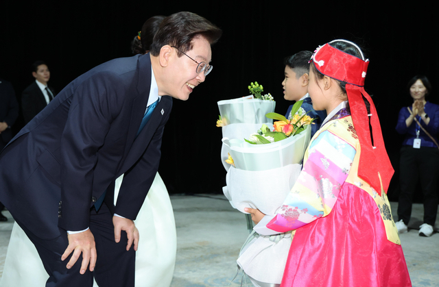 이재명 대통령과 김혜경 여사가 10일(현지시간) 몽골 울란바타르 한 호텔에서 열린 동포 오찬간담회에서 화동과 인사하고 있다. 연합뉴스