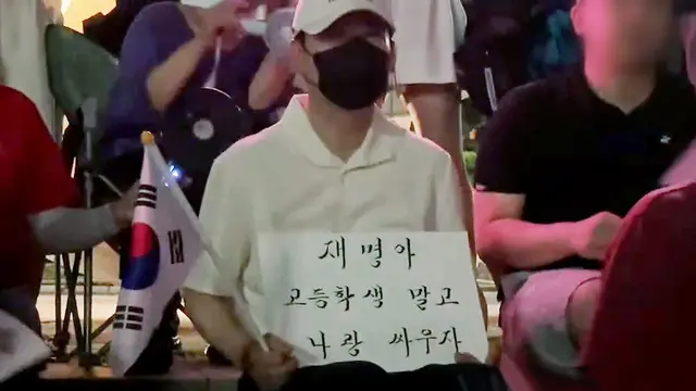 6·3 지방선거 국민의힘 참패 이후 사퇴론에 직면한 장동혁 국민의힘 당대표가 지난 7월 7일쯤 잠실 개표소 봉쇄시위에서 잠행하며 “재명아 고등학생 말고 나랑 싸우자” 손팻말을 든 모습. [유튜브 ‘정의구현 박완석’ 영상 갈무리]