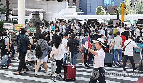제주국제공항에 도착한 관광객들이 대합실을 빠져나와 렌터카 주차장으로 향하고 있는 모습. [제주=연합뉴스]