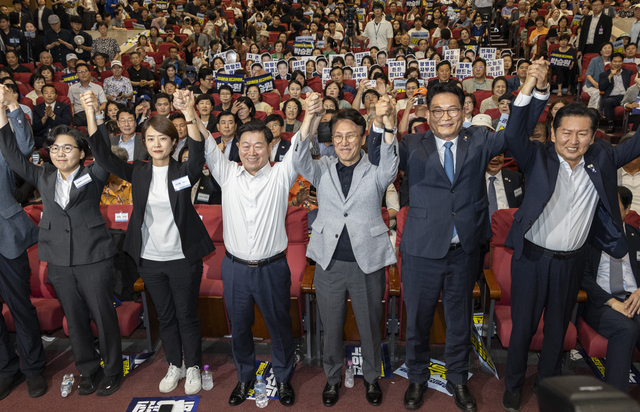 12일 국회 의원회관에서 열린 전국자치분권민주지도자회의(KLDC)에 더불어민주당 당 대표 후보 주자들과 자치분권회의 상임대표인 박승원 광명시장이 손을 들어 인사하고 있다. (오른쪽 부터) 정청래 전 대표, 송영길 의원, 김민석 전 총리, 박승원 광명시장, 고민정 의원, 김보미 전 강진군 의원. [연합뉴스]