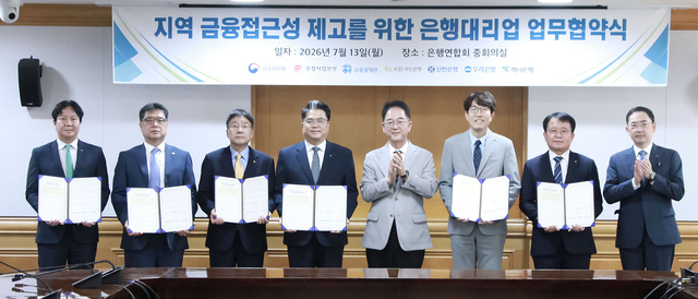 김진홍(오른쪽 네번째) 금융위원회 금융산업국장이 13일 서울 중구 은행회관에서 은행대리업의 실제 사업시행 주체인 우정사업본부, 금융결제원 및 4대 은행(KB국민·신한·하나·우리)과 은행대리업 업무협약(MOU) 체결식에 참석한 후 기념촬영을 하고 있다. [금융위원회 제공]