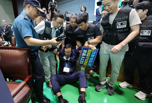15일 오후 충북 충주시장 당선무효 소청과 관련한 재검표가 진행되는 국립한국교통대학교 다목적 강당에서 소청인인 맹정섭 더불어민주당 전 충주시장 후보가 개표 시작을 막아서다가 강제 퇴거 조치 당하고 있다. [연합뉴스]