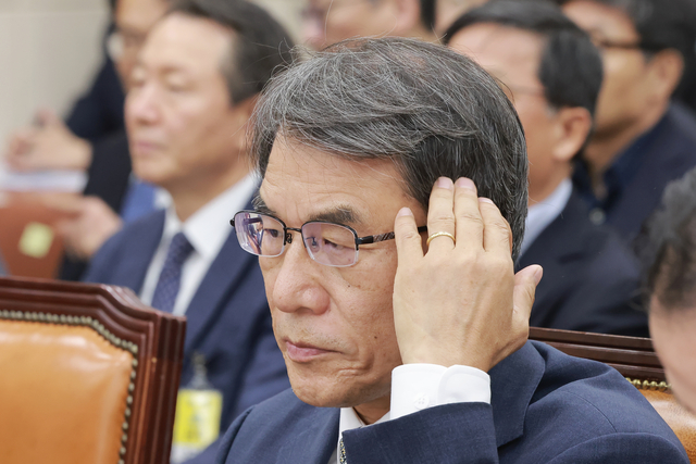 노태악 전 중앙선거관리위원장이 14일 국회에서 열린 ‘제9회 전국동시지방선거 투표용지 부족 사태 등 국민 참정권 침해 진상규명 및 선거관리 개혁을 위한 국정조사 특별위원회’ 제1차 청문회에서 머리카락을 만지고 있다.  [연합뉴스]