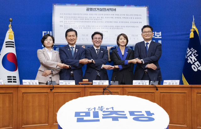 더불어민주당 8.17 전당대회에서 당 대표직에 출마하는 후보들이 20일 국회에서 열린 공명선거 실천 서약식에 참석해 문서에 서명한 뒤 손을 맞잡고 기념 촬영하고 있다. (왼쪽부터) 김보미, 정청래, 김민석, 고민정, 송영길 후보. [연합뉴스]