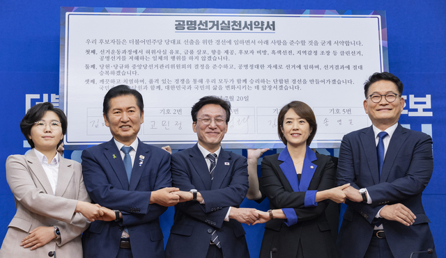 더불어민주당 8.17 전당대회에서 당 대표직에 출마하는 후보들이 20일 국회에서 열린 공명선거 실천 서약식에 참석해 문서에 서명한 뒤 손을 맞잡고 기념 촬영하고 있다. (왼쪽부터) 김보미, 정청래, 김민석, 고민정, 송영길 후보. [연합뉴스]