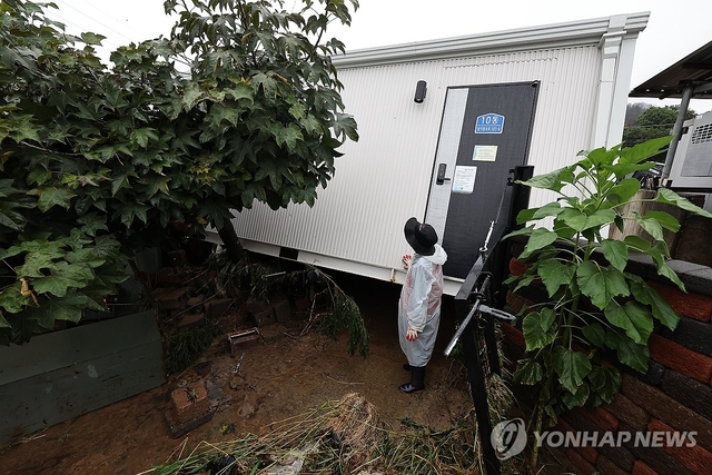 지난달 19일 경북 안동시 일직면 귀미1리에 설치된 산불 이재민 임시주택이 폭우에 떠밀려 인근 주택 담벼락을 뚫고 들어와 있다. 연합뉴스