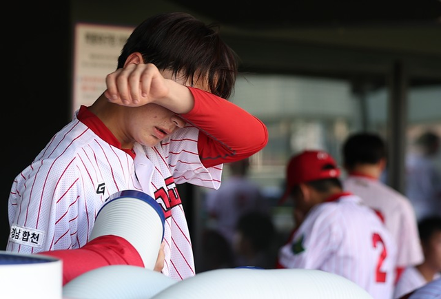 한 폭염 예보에 따라 제54회 봉황대기 전국고교야구대회가 개막일인 7일 오전 경기만 진행한다. 이날 서울 양천구 목동야구장에서 야로고등학교 선수가 땀을 닦고 있다. [연합뉴스]