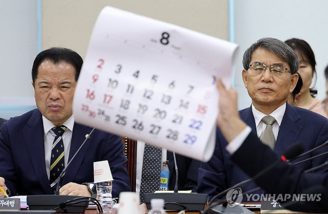 노태악 전 중앙선거관리위원장과 위철환 중앙선거관리위원장 직무대행이 10일 국회에서 열린 '제9회 전국동시지방선거 투표용지 부족 사태 등 국민 참정권 침해 진상규명 및 선거관리 개혁을 위한 국정조사 특별위원회' 제3차 청문회에서 더불어민주당 전용기 의원이 8월 달력을 들어 보이며 재검표 현장검증 날짜의 조속한 확정을 촉구하는 발언을 듣고 있다. 연합뉴스
