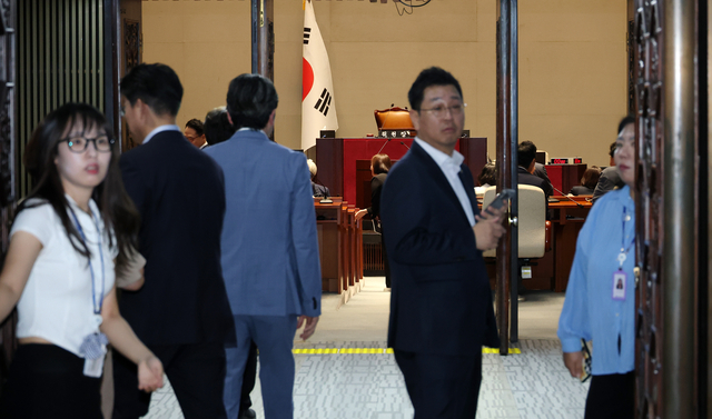 13일 국회에서 더불어민주당 비공개 의원총회가 열린 가운데 관계자들이 회의실 문을 닫고 있다. [연합뉴스]