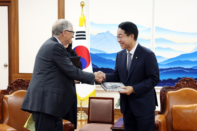 조정식 국회의장이 14일 국회에서 빌 게이츠 게이츠재단 이사장을 접견, 빌 게이츠 이사장의 회고록 ‘소스코드’를 선물 받고 악수하고 있다. 국회의장실 제공