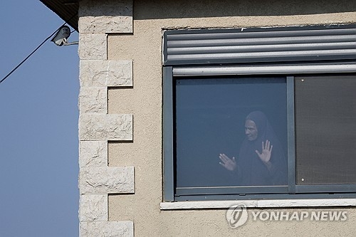 유대인 정착촌 운동가들이 봉쇄한 요르단강 서안 쿠스라 마을에서 한 팔레스타인 여성이 창밖을 내다보고 있다. 로이터 연합뉴스.