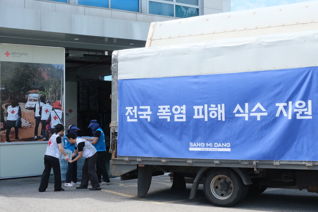 상미당홀딩스 해피봉사단이 지난 11일 서울 양천구 대한적십자사 재난안전센터에 폭염 피해 지원을 위한 생수를 전달하고 있다. [상미당홀딩스 제공]