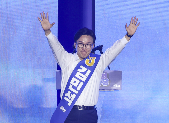 더불어민주당 당 대표에 출마한 김민석 전 총리가 17일 대전 컨벤션센터에서 열린 제3회 더불어민주당 정기 전국당원대회에서 연설대에 올라 인사하고 있다.   [연합뉴스]