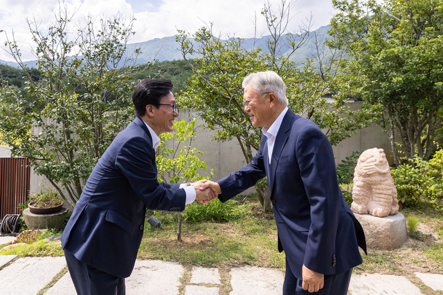 김민석 더불어민주당 대표(왼쪽)가 19일 경남 양산시 평산마을 문재인 전 대통령 사저를 방문해 문 전 대통령과 인사하고 있다. 민주당 제공