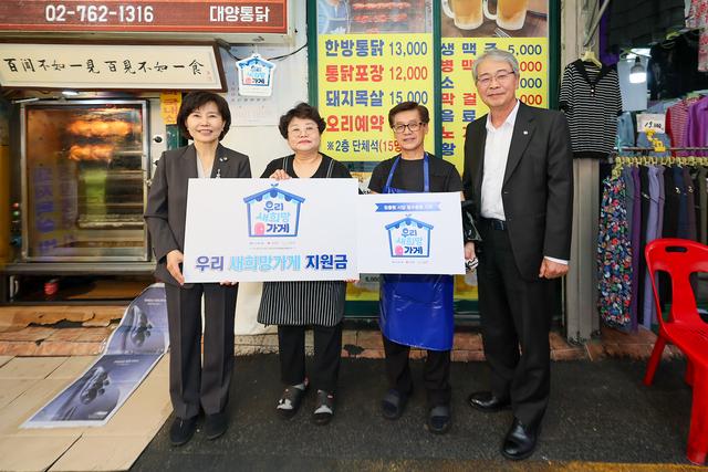 임종룡(오른쪽) 우리금융그룹 회장이 우리미소금융재단의 ‘새희망가게’로 선정된 곳에서 지원금을 전달한 후 기념촬영을 하고 있다. [우리금융 제공]
