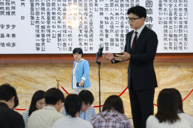 국회 법제사법위원장인 서영교(뒷편 왼쪽) 더불어민주당 의원이 9일 국회 본청 로텐더홀에서 김승원 법무부 장관 후보자 ‘가짜 신약 임상통과 식약처 로비·주가조작 관여 의혹’과 관련해 취재진 질문에 답하는 한동훈(오른쪽) 무소속 의원을 보며 지나가고 있다. [연합뉴스]