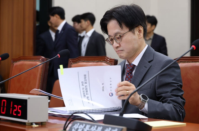 김정관 산업통상부 장관이 지난달 22일 국회 산업통상중소벤처기업위원회에 ‘대한민국과 미합중국 간 전략적투자의 운영 및 관리를 위한 특별법’에 따른 대미투자 1호 사전보고를 하기 전 자료를 살펴보고 있다. 연합뉴스