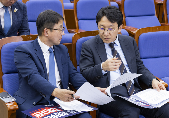 더불어민주당 한병도 원내대표(왼쪽)과 천준호 원내운영수석부대표가 1일 국회에서 열린 의원 총회 도중 대화하고 있다. 연합뉴스